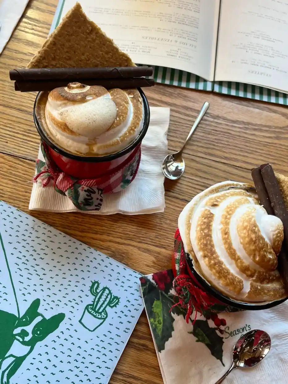 Gourmet hot cocoa topped with toasted marshmallow and chocolate sticks, served in festive decor, showcasing a cozy winter wedding drink option at The Pearl at Crawford Farm.
